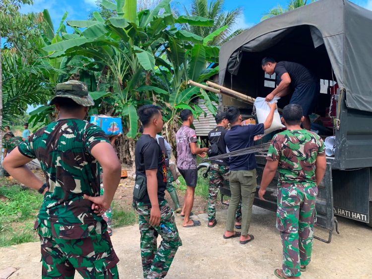 Anggota Satgas TMMD Reguler Perbatasan Ke-129 Kodim 1206/Putussibau Gotong Royong Turunkan Material Pembangunan Menuju Desa Belatung Embaloh Hilir