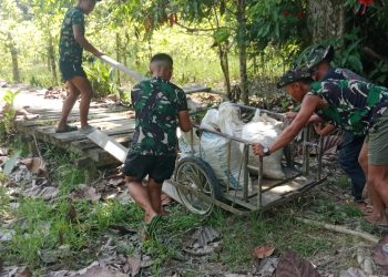 Personel Satgas TMMD ke 129 Dorong Gerobak Angkut Material Demi Impian Warga