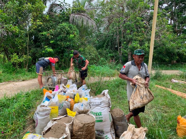 Kebersamaan Anggota Satgas TMMD Kodim 1206/Putussibau dan Warga Saat Angkat Pasir dari Sungai untuk Pembangunan MCK di Desa Belatung