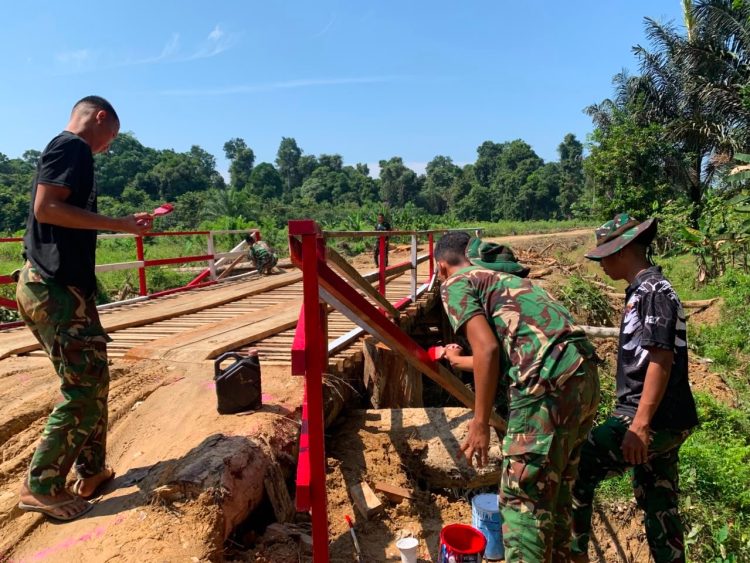 Percantik Infrastruktur Desa, Prajurit TMMD Regtas Ke-129 Kodim 1206/Putussibau Lakukan Pengecatan Jembatan Kerato