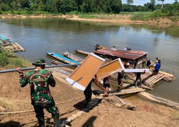 Semangat Anggota Satgas TMMD Kodim 1206/Putussibau Saling Bahu-Membahu Naikkan Material Bangunan ke Perahu Menuju Desa Belatung