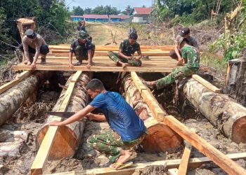 Semangat Gotong Royong TNI-Polri dan Warga Warnai Pembangunan Jembatan Danau Belatung pada TMMD Regtas Ke-129 Kodim 1206/Psb