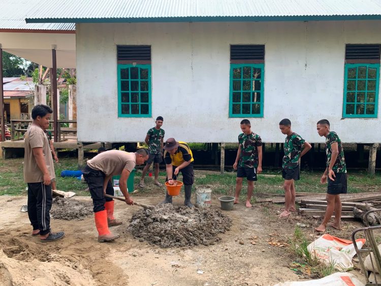 Sinergi TNI-Polri Kian Solid, Satgas TMMD Regtas Ke-129 Kodim 1206/Putussibau Kompak Aduk Semen Bangun MCK Gereja Santo Fransiskus Xaverius